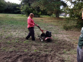 Mary Claire pushes the rototiller at the Freedom Farm.