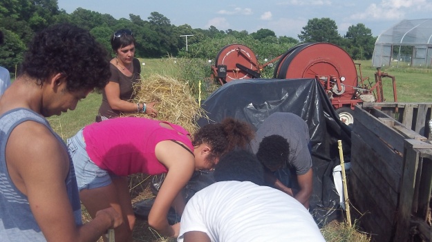 Apprentice Angela Entzel leads the SWARMers in building a hot compost pile.